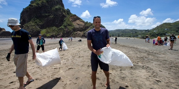 American singer-songwriter Jack Johnson does his bit at Piha yesterday during the beach clean-up organised by Sustainable Coastlines. Photo / Brett Phibbs