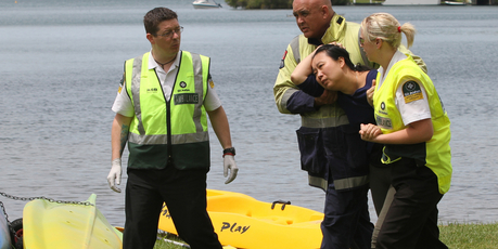 A woman is comforted by emergency staff as police begin a search of Lake Tarawera to recover two people, believed to have drowned in a kayaking incident. Photo / SNPA / Peter Graney