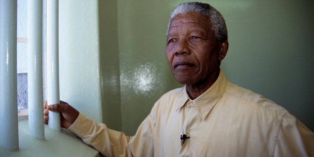 Nelson Mandela stands at the window of the cell where he was incarcerated for more than two decades. Photo / AP