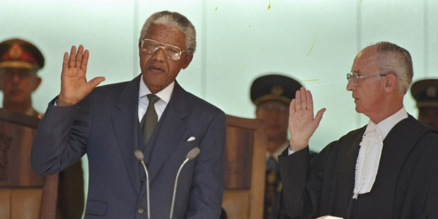 Nelson Mandela, left, takes the oath of office in Pretoria, South Africa, to become the country's first black President. Photo / AP