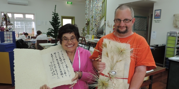 WELL RAPT: Jonette Ruatara, left, and Steve Blagrove from The Paper Mill with the birthday gift and calligraphy message Whangarei has presented to the Japanese Consular General to honour the emperor's birthday. PHOTO/SUPPLIED