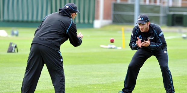 Kane Williamson catches throws from coach Mike Hesson at University Oval in Dunedin yesterday but is still in doubt for the first test. Photo / ODT