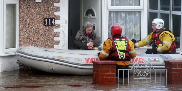 A woman and her dog are rescued by the RNLI or Royal National Lifeboat Institute in Rhyl, Wales. Photo / AP