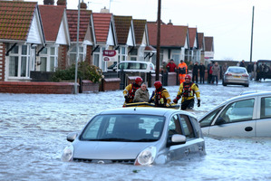 People are rescued by the RNLI from the floods as heavy seas and high tides sweep across the country, in Rhyl, Wales. Photo / AP