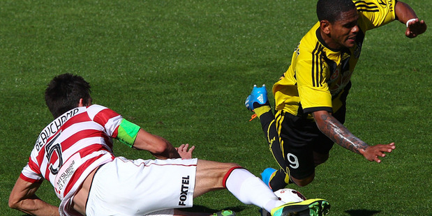 Kenny Cunningham of the Phoenix is brought down in the tackle of Michael Beauchamp of the Wanderers. Photo / Getty Images