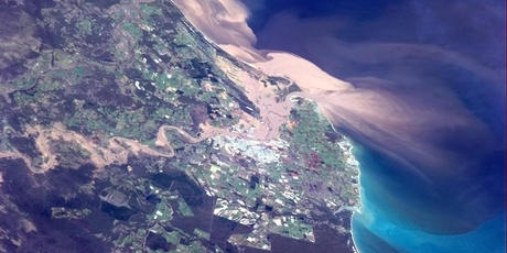 Floodwaters can be seen pouring into Bundaberg in this photo taken from the International Space Station. Photo / Commander Chris Hadfield/ISS