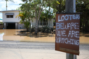 A sign is put up in East Bundaberg after reports of looters as parts of southern Queensland experiences record flooding. Photo / Getty Images