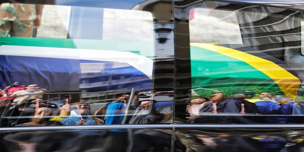 A vehicle carrying the body of Nelson Mandela makes its way through the streets of Pretoria. Photo / AP