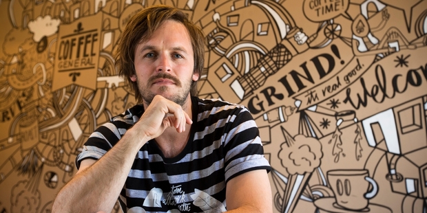Artist Allan Wrath with one of his works at the Coffee General Store in Birkenhead. Photo / Greg Bowker