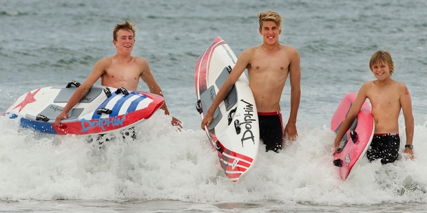 Fletcher Swan (left), Josh Jarvis and Jayden Rutten (right) in the surf at Omanu Beach yesterday. Picture / Alan Gibson