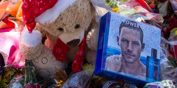 Flowers and messages are left at a memorial rally and car cruise in Valencia, California to remember actor Paul Walker and his friend Roger Rodas.