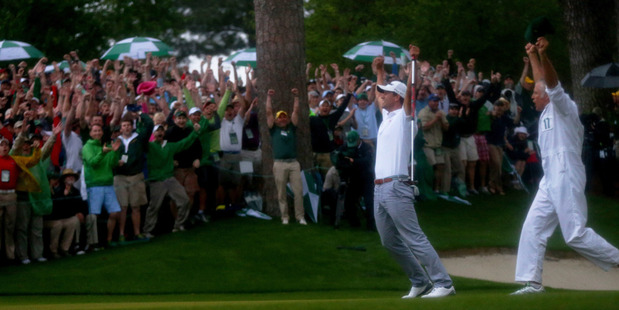 Adam Scott of Australia reacts alongside caddie Steve Williams after Scott makes a birdie putt on the second sudden death playoff hole. Photo / Getty Images.