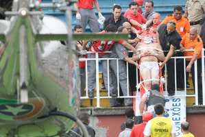 An injured fan is carried on a stretcher after clashes with team fans during a Brazilian league soccer match between Atletico Paranaense and Vasco da Gama. Photo / AFP