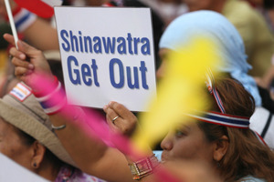 Thai anti-government protesters hold a placard in front of the Government House, in Bangkok. Photo / AP