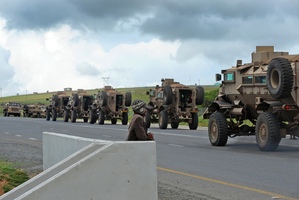A young boy watches as a military convoy takes positions near the home and where the late South African president Nelson Mandela will be buried in Qunu, South Africa. Photo / AP