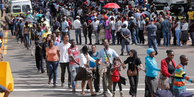 Hundreds of people join hands while going up a hill to view the body of former South African president Nelson Mandela in Pretoria. Photo / AP