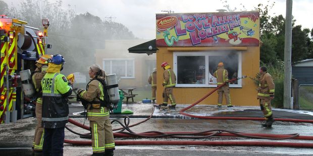 Fire crews from Featherston surround the Signal Box Dairy, dousing the interior and roof cavity.