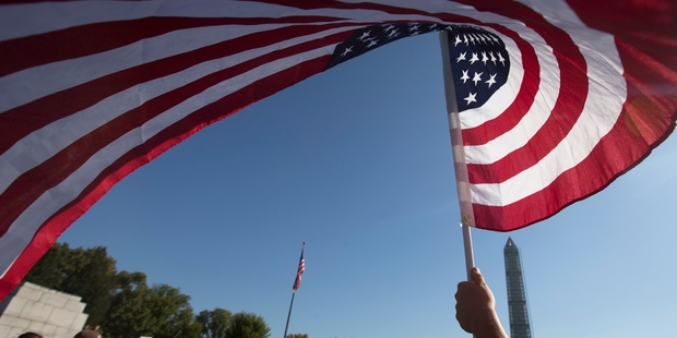 Americans are less enthusiastic than they once were about waving the flag around the world, a poll reveals. Instead they believe their nation's power and prestige are waning Photo / AP