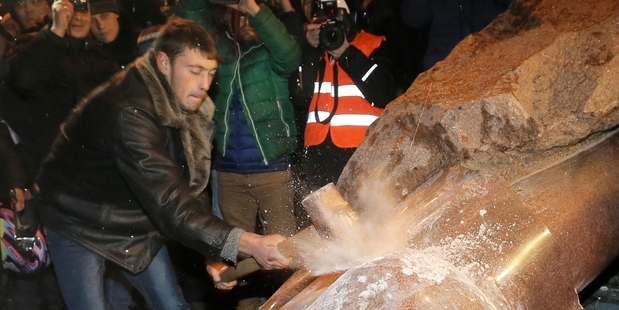 Pro-European Ukrainians smash a statue of Lenin in protest at the Government's pursuit of closer ties to Russia at the expense of the West. Photo / AP