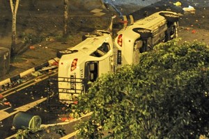 Two police cars flipped to their sides remain in the street after a riot broke out in Singapore. Photo / AFP