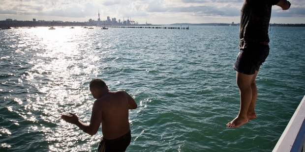 Josh Tomai, 14, and Tarahawaiiki Hawk, 15, cool off from Okahu Wharf near Mission Bay. Photo / Greg Bowker