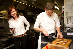 Amelia Wade watches the timer as Geoff Scott of Vinnie's in Herne Bay attempts one of Jamie Oliver's 15 minute meals. Photo / Sarah Ivey
