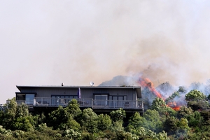 Flames close to a home in Tumbledown Bay Rd, Port Underwood, near Picton. Photo / Andrew Lucas