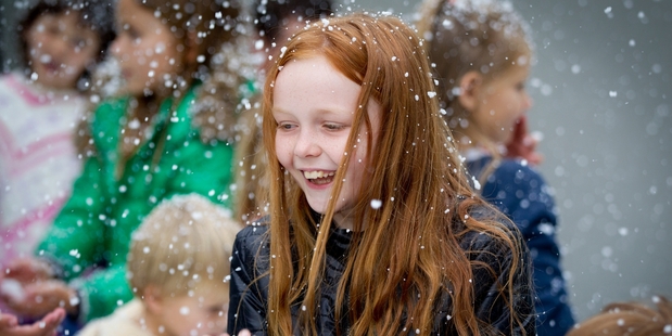 Ashley Hook, 10, has the joy of Christmas snow without the cold as the snow machine works its magic at the Franklin Rd street of lights in Freemans Bay, Auckland. Photo / Sarah Ivey