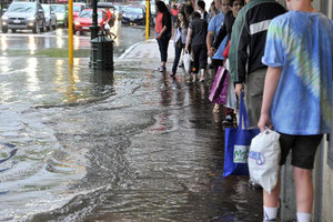 George St or George River? Shoppers on Dunedin's main street try to keep high and dry yesterday. Photo / ODT