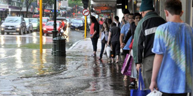 George St or George River? Shoppers on Dunedin's main street try to keep high and dry yesterday. Photo / ODT