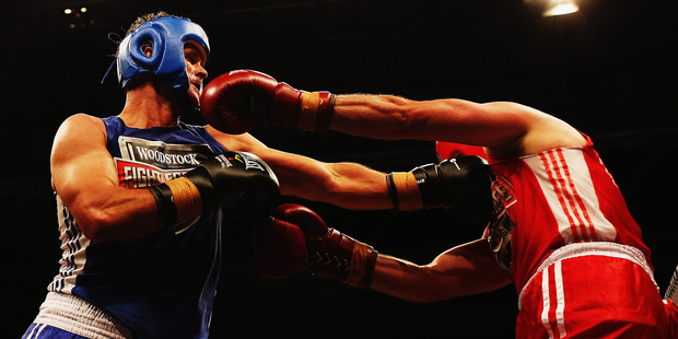 Chris Cairns , blue, lands a shot on Simon Doull. Photo / Getty Images