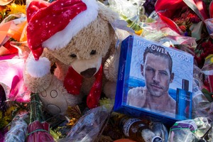 Flowers and messages are left at a memorial rally and car cruise in Valencia, California to remember actor Paul Walker and his friend Roger Rodas. Photo / AP