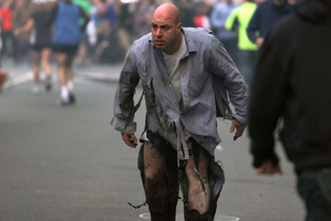 Boston Marathon bombing victim James Costello staggers away from the blast in torn clothing. Photo / Kenshin Okubo / AP