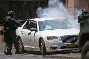 A police officer sprays tear gas into the vehicle to end the protest. Photo / AP