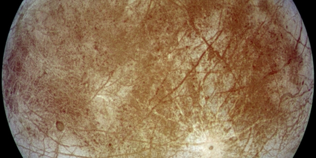 Dark brown material on the surface of Europa could have come from collisions with asteroids or comets, scientists say. Photo / Nasa
