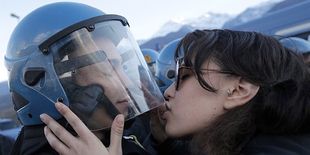Nina De Chiffre kisses a police officer during a protest in Susa. Photo / AFP