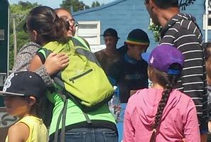 Family on the banks of the Whakatane River waiting while emergency services search for the missing boy. Photo / Greg Taipari