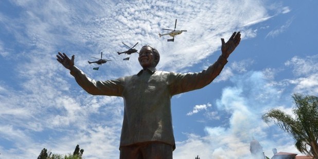 Helicopters carrying the South African flag fly over a 9-metre bronze statue of South African former president Nelson Mandela. Photo / AFP