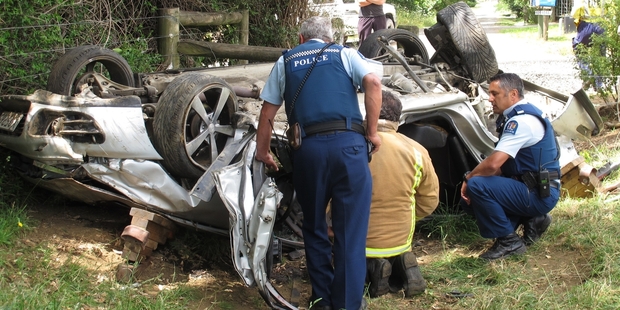 Police and firefighters inspect the wreckage after what was thought to have been a high-speed crash yesterday. Photo/Peter de Graaf.