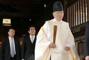 Shinzo Abe (centre) follows a Shinto priest to the shrine. Abe says the visit was an anti-war gesture. Photo / AP