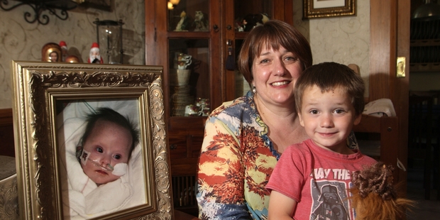 Litza Devine with 4-year-old Oliver, and a photo of 4-month-old baby Max who lost his fight to live last year. Photo/Bevan Conley