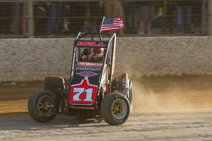 Chris Bell flies the flag for the United States during the feature midget car race at Western Springs. Photo / James Selwyn
