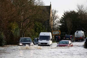 Torrential rain turned this road near Reigate in England into a river. Other areas of the country were also hit by flooding, and transport was disrupted. Photo / AP