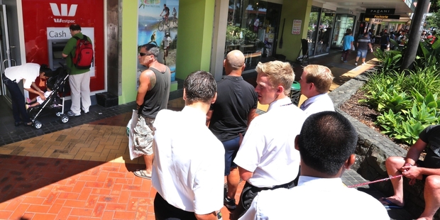 Shoppers queue to remove cash from an ATM on Cameron Street. Photo/John Stone
