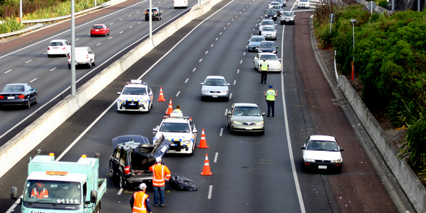 A vehicle rolled seriously injuring an occupant and closing the motorway to the airport, Mangere. Photo / SNPA / Grahame Clark