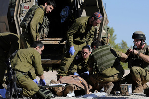 Israeli army paramedics treat a civilian shot near the Israel and Gaza border, Tuesday. Photo / AP
