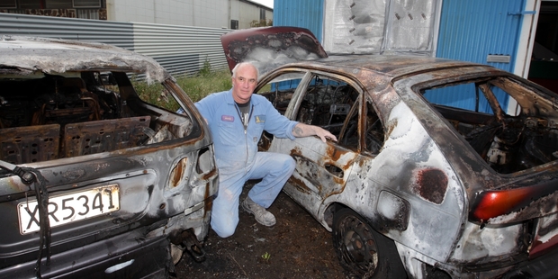 DESTROYED: Aztech Panel Beaters owner Ross Cocking with his two courtesy cars torched by vandals last weekend. PHOTO/PAUL TAYLOR HBT134144-01
