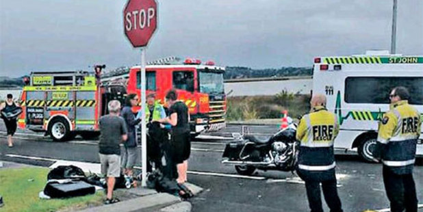 CRASH SCENE: A police officer talks with witnesses at the scene of yesterday's serious motorcycle crash at Westshore.