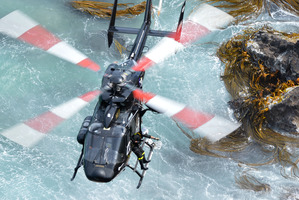 An injured fisherman is winched aboard the Otago Regional Rescue helicopter after the vessel he was in drifted aground. Photo / APN