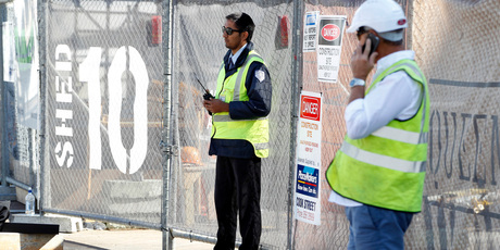 A security guard keeps watch on the closed Mainzeal construction site at Shed 10, Queens Wharf. Photo/ Michael Craig